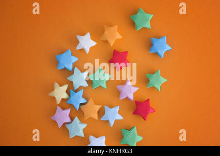 Colorful origami lucky stars on yellow background. Close up. Stock Photo
