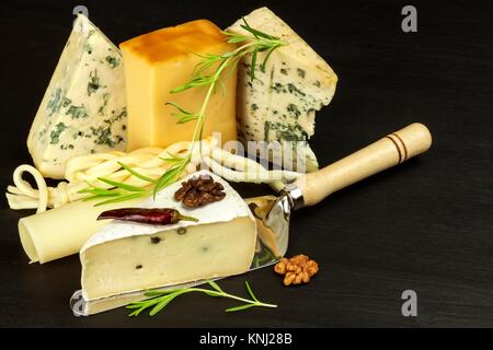 Different types of cheeses on the kitchen table. Preparation of snacks. Healthy food Stock Photo