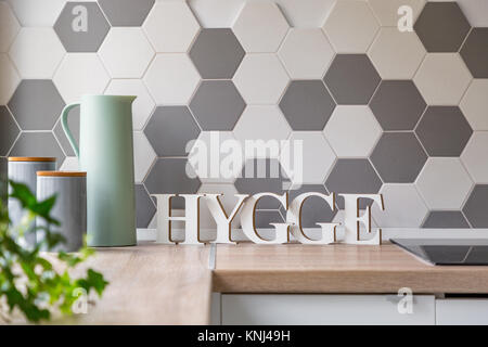 Modern kitchen interior in scandinavian style with wooden countertop and honeycomb wall tiles Stock Photo