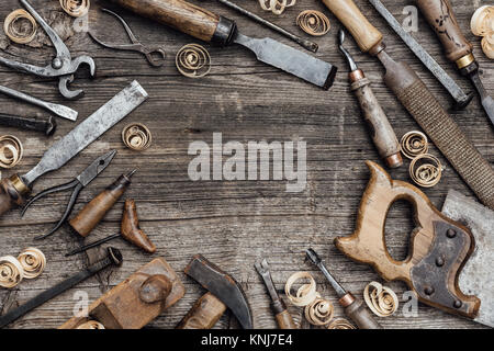 Old used woodworking tools on a vintage workbench composing a frame: carpentry, craftsmanship and handwork concept Stock Photo