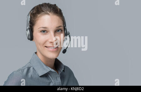 Smiling beautiful woman with headset: call center and customer support operator Stock Photo