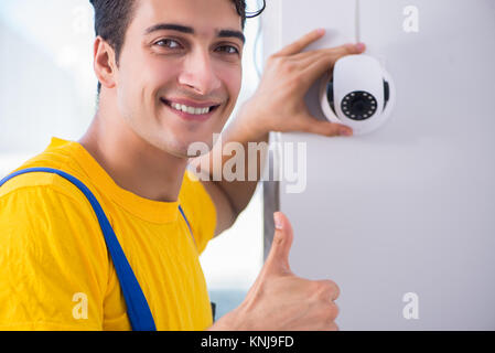 Contractor installing surveillance CCTV cameras in office Stock Photo