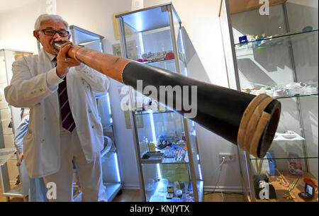 Alfeld, Germany. 04th Dec, 2017. Josef Alexander Wirth, head of the snoring museum, blows into a Didgeridoo instrument at the museum in Alfeld, Germany, 04 December 2017. Playing the Didgeridoo has positive effects on the consecutive symptoms of the Obstructive Sleep Apnea Syndrome. In his exhibition, Wirth is presenting about 300 objects related to the subject of 'snoring' - including therapeutic possibilities. Credit: Holger Hollemann/dpa/Alamy Live News Stock Photo