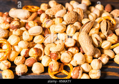 Close up of a lot of different nuts on dark wooden desk. Food and beverages concept Stock Photo
