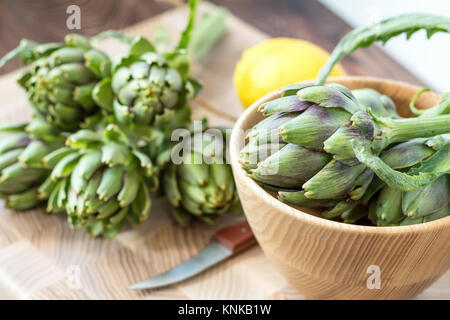 Two artichoke bouquets on kitchen table among some kitchen items Stock Photo
