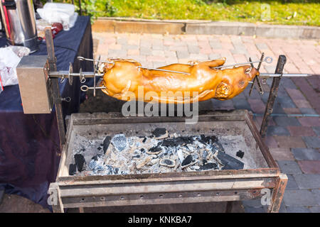 Roasted pig on a traditional spit outdoor. Food and beverages concept Stock Photo