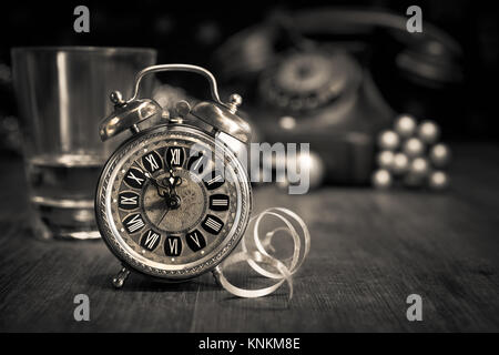 Composition with vintage alarm clock showing five to midnight and an old phone. Happy New Year 2015! Stock Photo