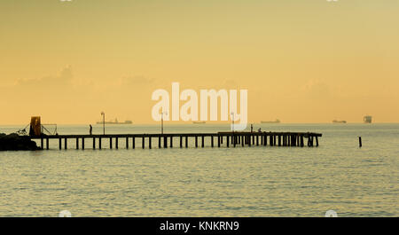 pier at sunrise , fishing pier extending into the sea Stock Photo