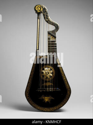 A harp lute crafted by Edward Light around 1815 in London. This instrument combines features of a harp and lute, featuring twelve catgut strings and a curved neck supported by a front pillar. The pitch of the bass strings can be altered by thumb-operated ring stops, functioning similarly to pedals on a harp. Stock Photo