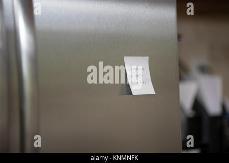 Sticky note reminders stuck on the refrigerator in the kitchen. Stock Photo