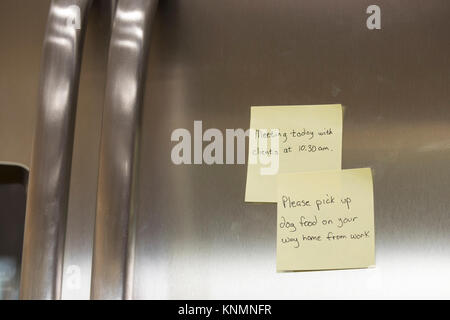 Sticky note reminders stuck on the refrigerator in the kitchen. Stock Photo