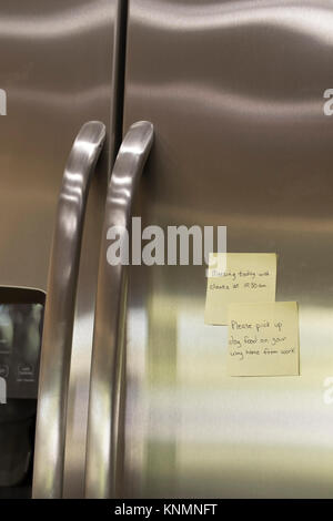 Sticky note reminders stuck on the refrigerator in the kitchen. Stock Photo