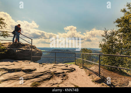 A loving couple kissing on top of Lilienstein mountain. In love with a trip. Kissing. Concept of a happy people. Falling in love. Stock Photo