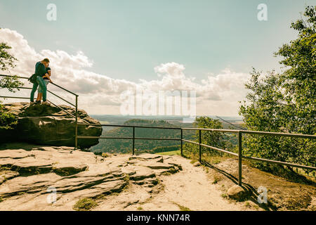 A loving couple kissing on top of Lilienstein mountain. In love with a trip. Kissing. Concept of a happy people. Falling in love. Stock Photo