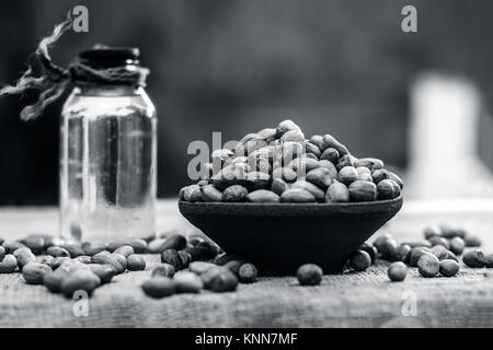 [Arachis hypogaea] Raw Groundnut in a clay bowl with groundnut oil on a gunny background.; Stock Photo