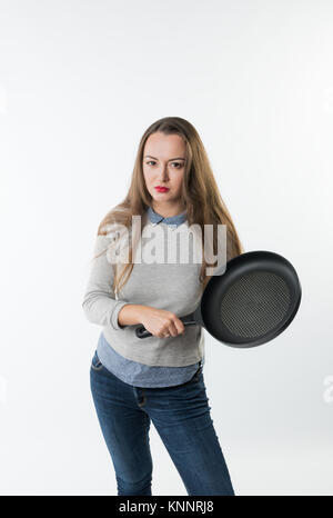 pretty woman with rage, umbragem, insult on her face and frying pan Stock Photo