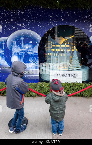 Christmas scene people, children looking at Saks Fifth Avenue Christmas Holiday window in downtown Toronto, Canada. Stock Photo