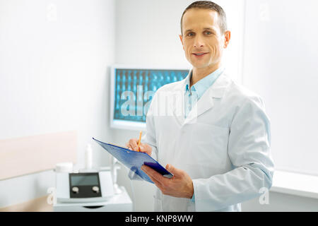 Delighted experienced doctor working in his office Stock Photo