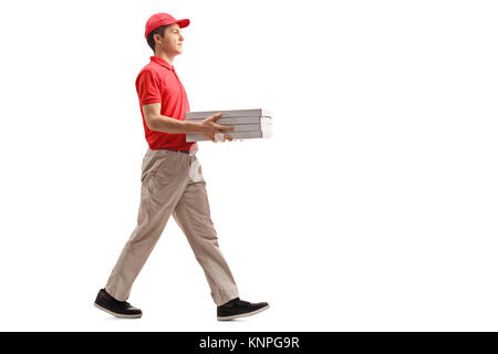 Full length profile shot of a teenage pizza delivery boy with pizza boxes walking isolated on white background Stock Photo