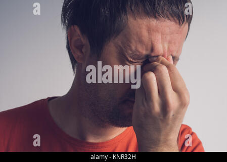 Man with migraine headache, adult caucasian male suffering from severe pain in head. Stock Photo
