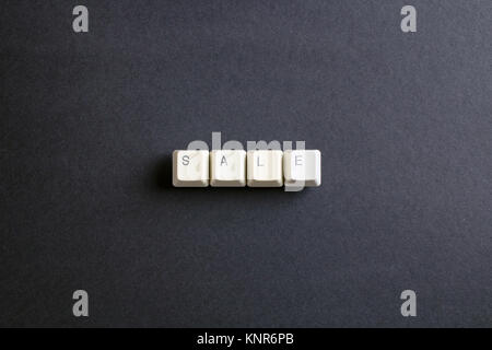 Sale word concept. Flat lay view from above on the table with computer keyboard keys buttons on a dark background. Stock Photo