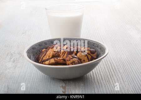 Oatmeal Cookies in bowl and Glass Of Milk on wooden table. Stock Photo