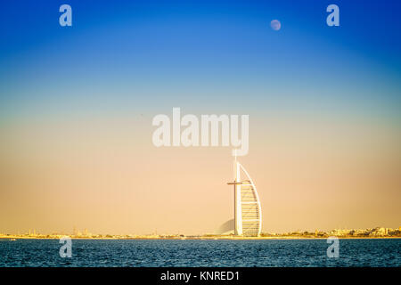 Dubai, UAE, November 12, 2016: moon is rising over Burj Al Arab - the world's only 7-star luxury hotel Stock Photo