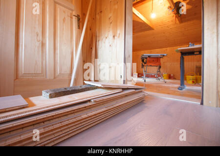 New whitened oak parquet flooring laid in an older house with pile of wooden boards. Professional work in progress, home improvement and renovation, c Stock Photo