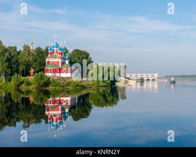 red church with blue domes from Uglich town on the shore surrounded by green trees, view from Volga river at sunny summer day Stock Photo