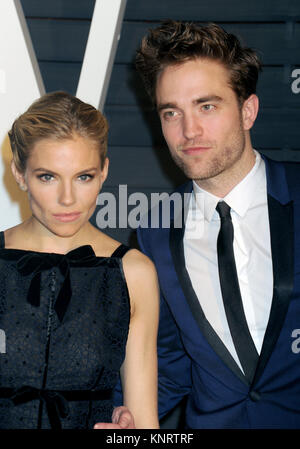 BEVERLY HILLS, CA - FEBRUARY 22:  Sienna Miller, Robert Pattinson attends the 2015 Vanity Fair Oscar Party hosted by Graydon Carter at Wallis Annenberg Center for the Performing Arts on February 22, 2015 in Beverly Hills, California  People:  Sienna Miller, Robert Pattinson Stock Photo