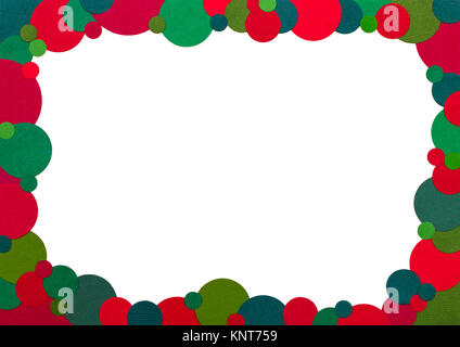 A frame made up of dots of a coloured paper using traditional christmas colours to form a rectangular frame with a white background Stock Photo