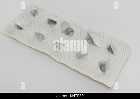 pills plate of remedy for food poisoning. all tablets taken, paper torn and black trace left Stock Photo