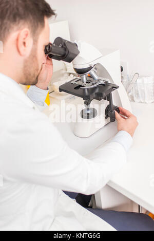 Close up view at the doctor looks through the microscope Stock Photo