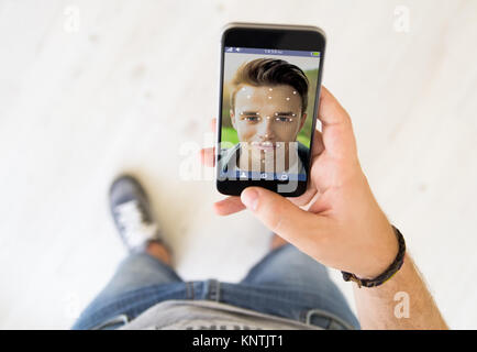 close up of male hand using face id technology on smart phone Stock Photo