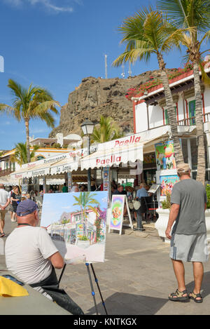 A man painting a picture of a restaurant in Puerto De Mogan Stock Photo