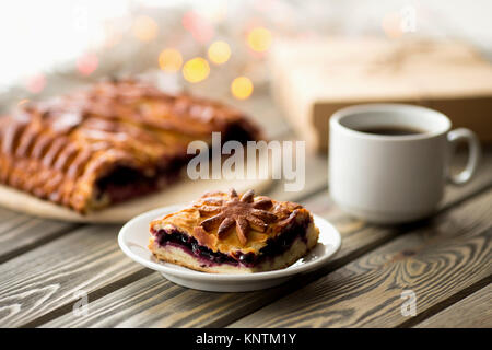 Piece of cake on the Christmas table. Christmas Lights and Decor. Sweets. Stock Photo