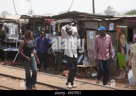 People walking home with shopping through slums of Kibera in Nairobi, Kenya, East Africa Stock Photo