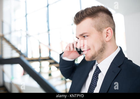 Closeup of young businessman using smartphone in office Stock Photo