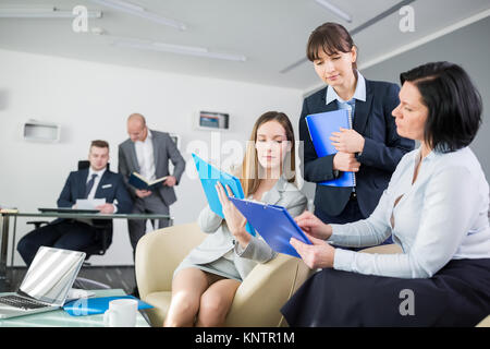 Businesswoman having discussion during meeting with colleagues in background at office Stock Photo