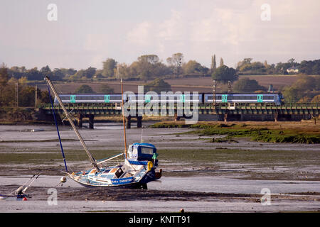 A train crossing over the mudflats of the river Stour between Manningtree and Cattawade in Essex, England. Stock Photo