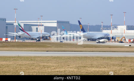 HAMBURG, GERMANY - MARCH 7th, 2014: A Emirates and Lufthansa A380 plane are being fitted in front of the Airbus plant in Hamburg Finkenwerder Stock Photo