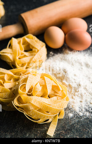 Raw tagliatelle pasta, flour and eggs. Stock Photo