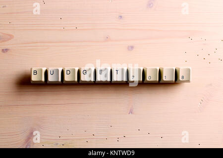 Budget 2018 new year. Flat lay view from above on the table with computer keyboard keys buttons on a wooden background. Stock Photo