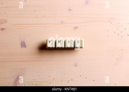 Xmas word. Flat lay view from above on the table with computer keyboard keys buttons on a wooden background. Xmas concept. Stock Photo
