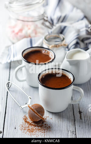 https://l450v.alamy.com/450v/knwca8/hot-cocoa-in-two-enameled-white-mugs-on-a-light-wooden-table-knwca8.jpg