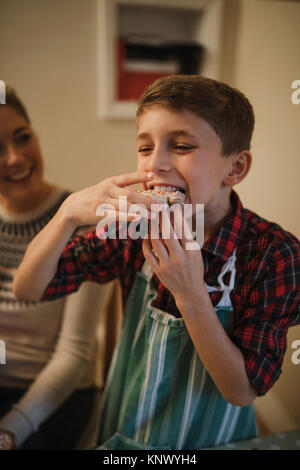 Little boy is tucking in to a homemade christmas biscuit. Stock Photo