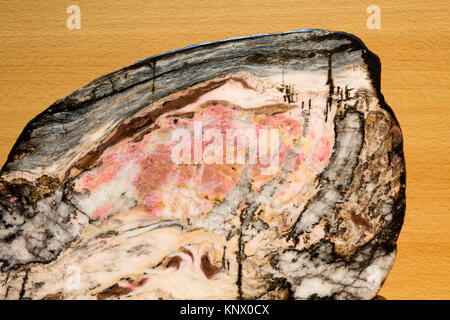 Pink rhodonite contrasting with black manganese oxides, cut in half, specimen from Hualien, Taiwan Stock Photo