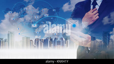 Double exposure of businessman using the tablet for sending the email on world map with network line over the cityscape background, business concept,E Stock Photo