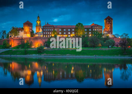 Poland city color, view at night across the Vistula River towards the illuminated Castle fortifications on Wawel Hill Krakow, Poland. Stock Photo