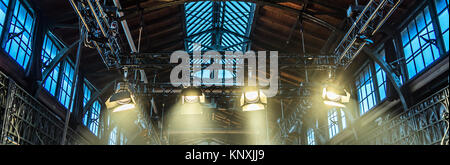 Spotlight on the ceiling of a former factory hall for lighting during a concert with rock music Stock Photo